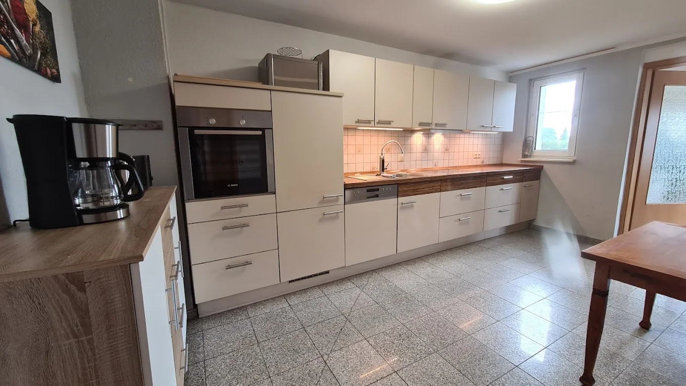 Küche mit Backofen, Kochfeld und Kaffeemaschine